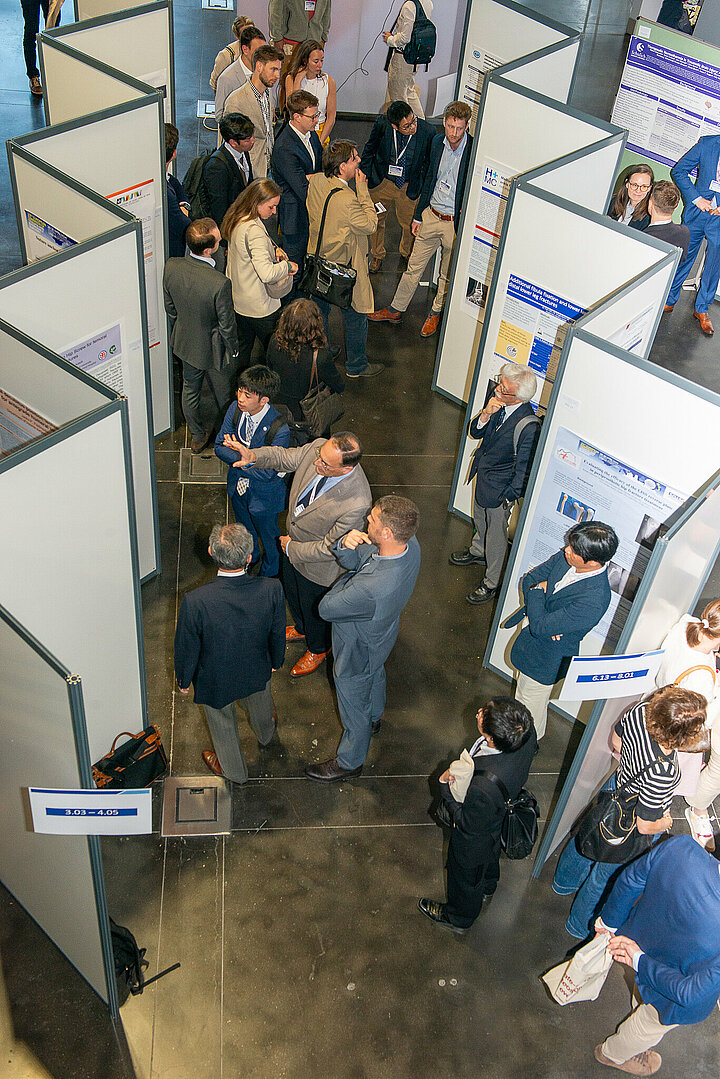 Participants stand in the poster exhibition