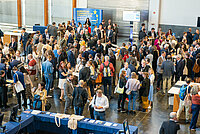 Participants stand in the entrance hall of the Estoril Convention Centre during the break